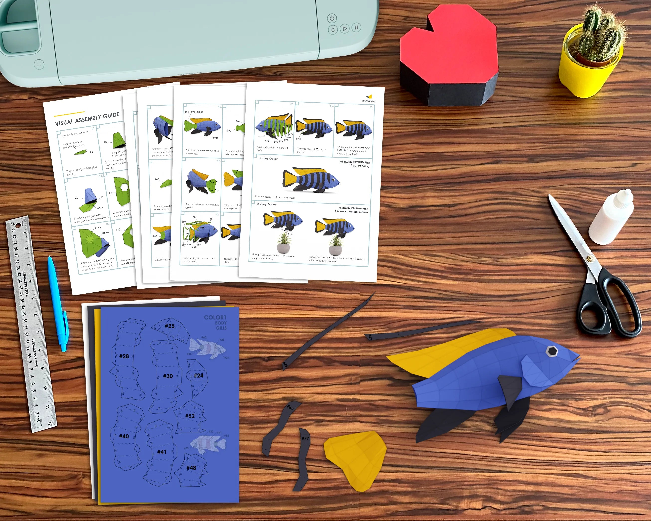 African Cichlid 3D papercraft assembly instructions with printed templates, cut pieces, and tools for DIY crafting.