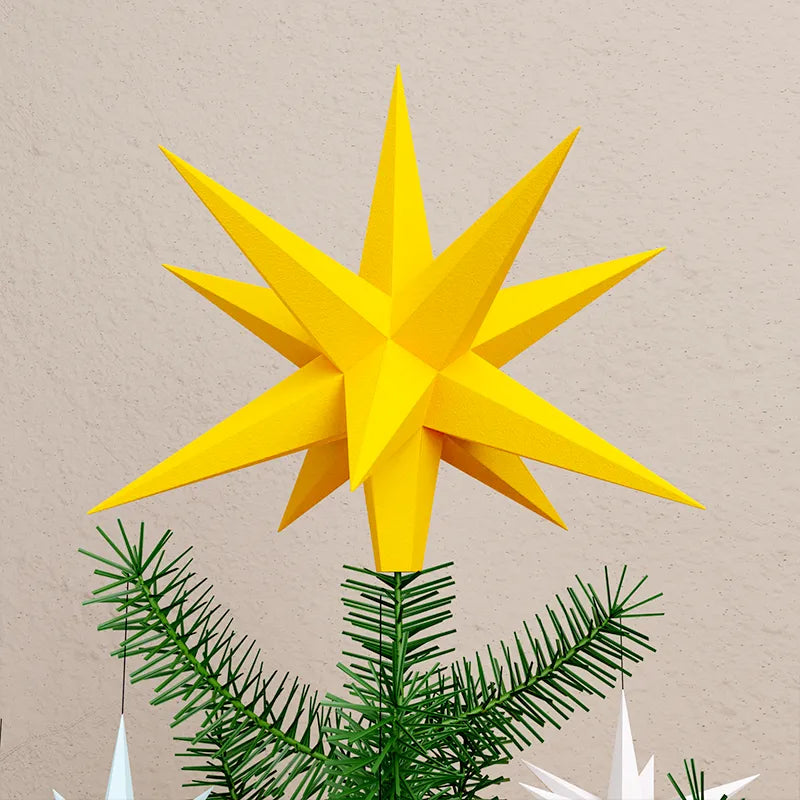 Detail of a paper Christmas tree topper on the decorated Christmas tree.