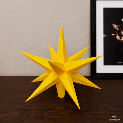 Finished low-poly 3D paper Christmas star tree topper in yellow on a tabletop.