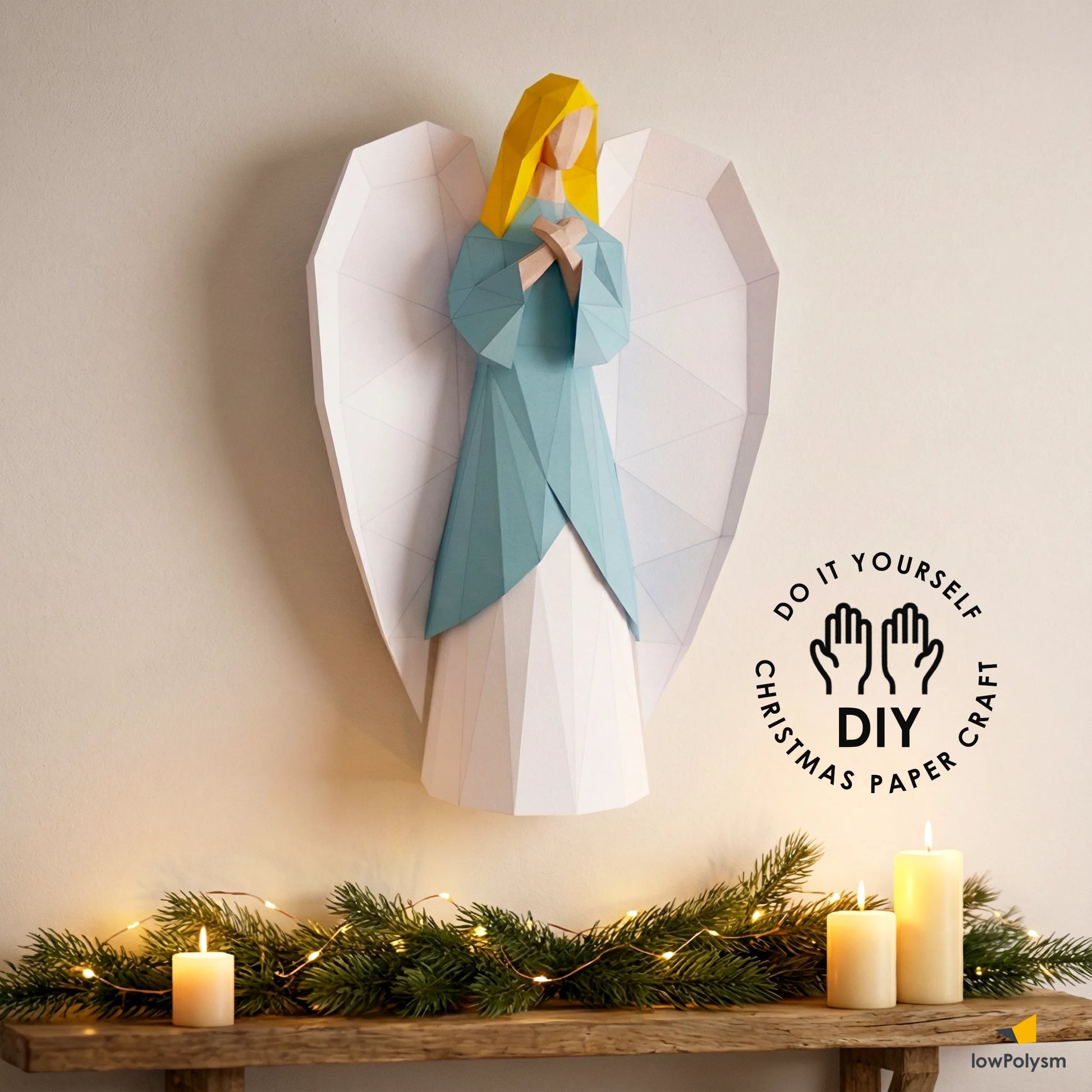 Decorative angel lowpoly paper wall sculpture with a DIY logo on a table with candles and Christmas greenery.
