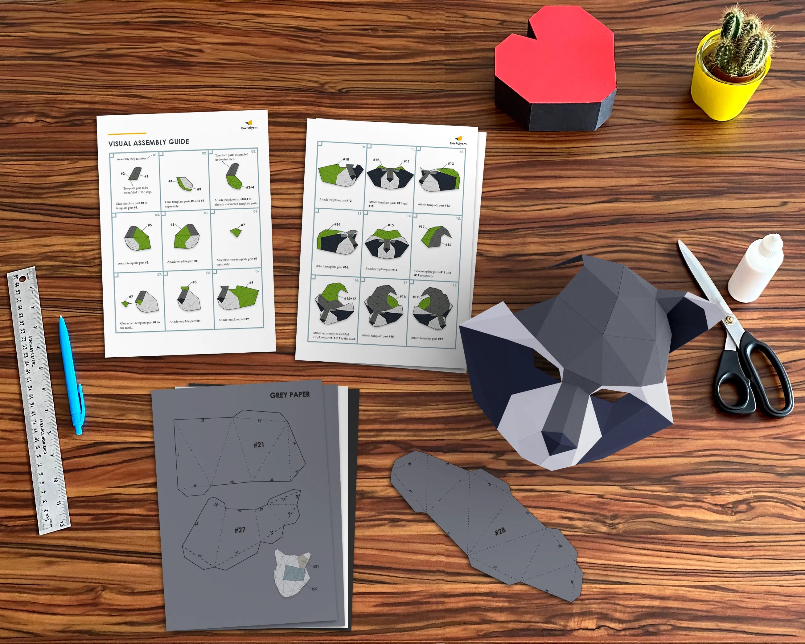 DIY 3D raccoon paper craft mask being assembled on a table with printed templates, scissors, glue, and folding instructions.